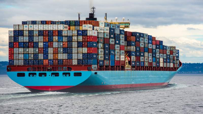 A picture of a shipping container fully loaded with containers at sea